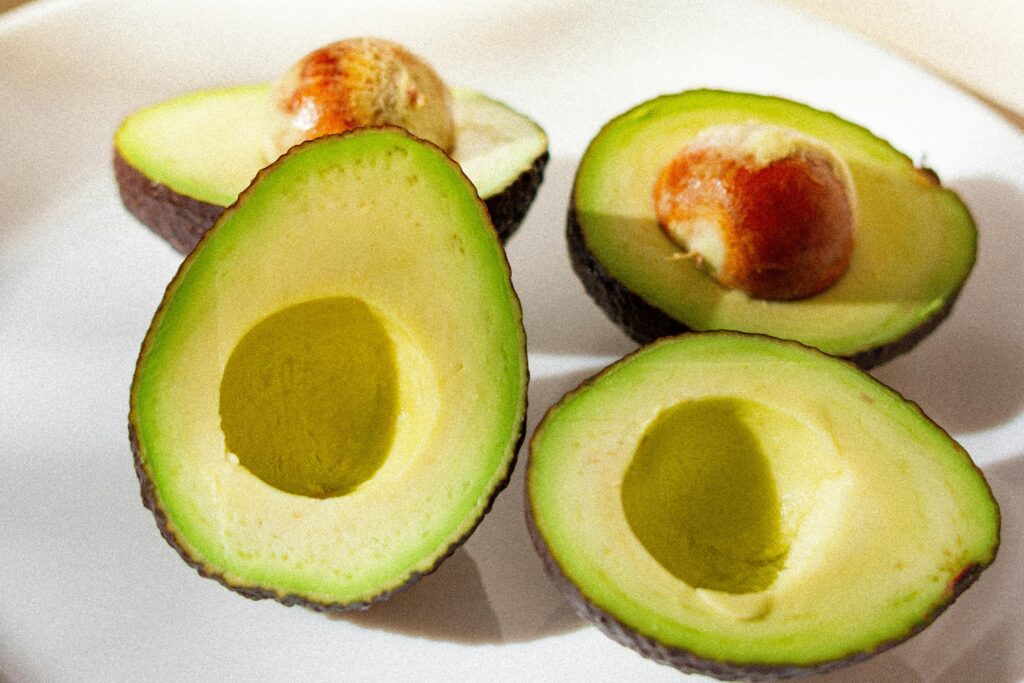 A close-up of ripe, sliced avocados arranged on a white plate.